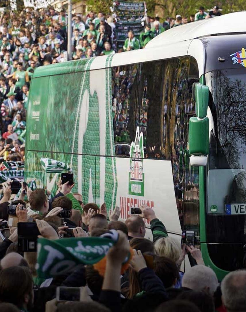 Der Mannschaftsbus von Werder Bremen inmitten von Werder-Fans