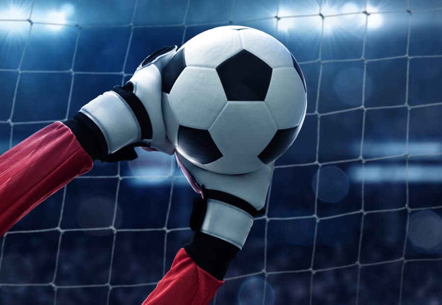 Die Hand eines Robokeepers hält einen Fußball
